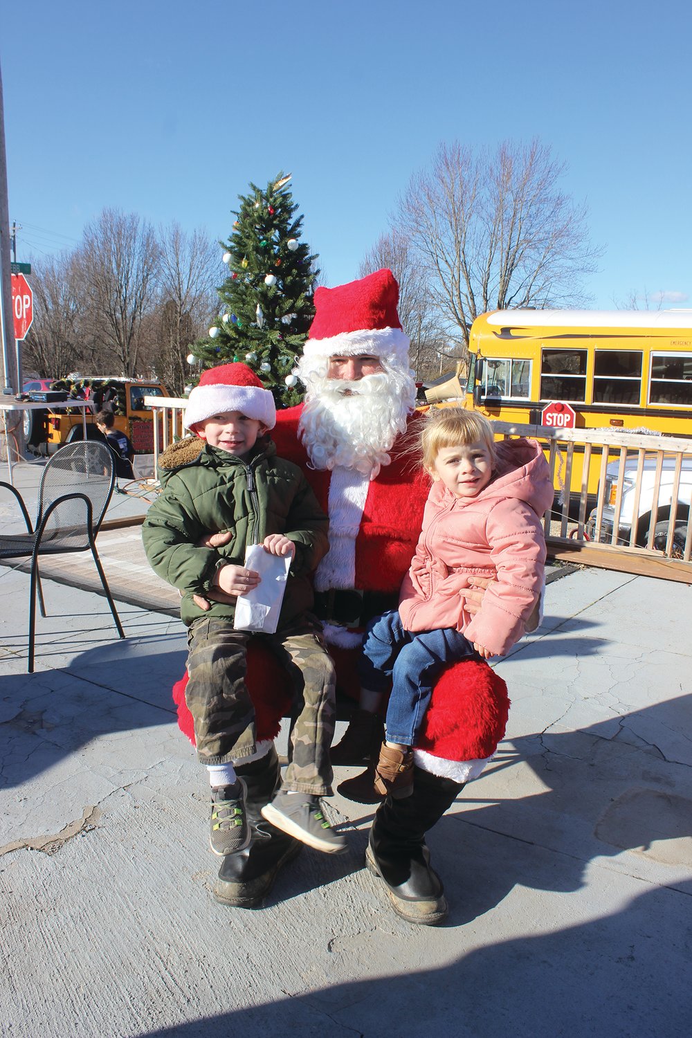 Enjoying a moment with Santa Claus after the Grovespring Christmas Parade is Gabriel and Sophia Berry.